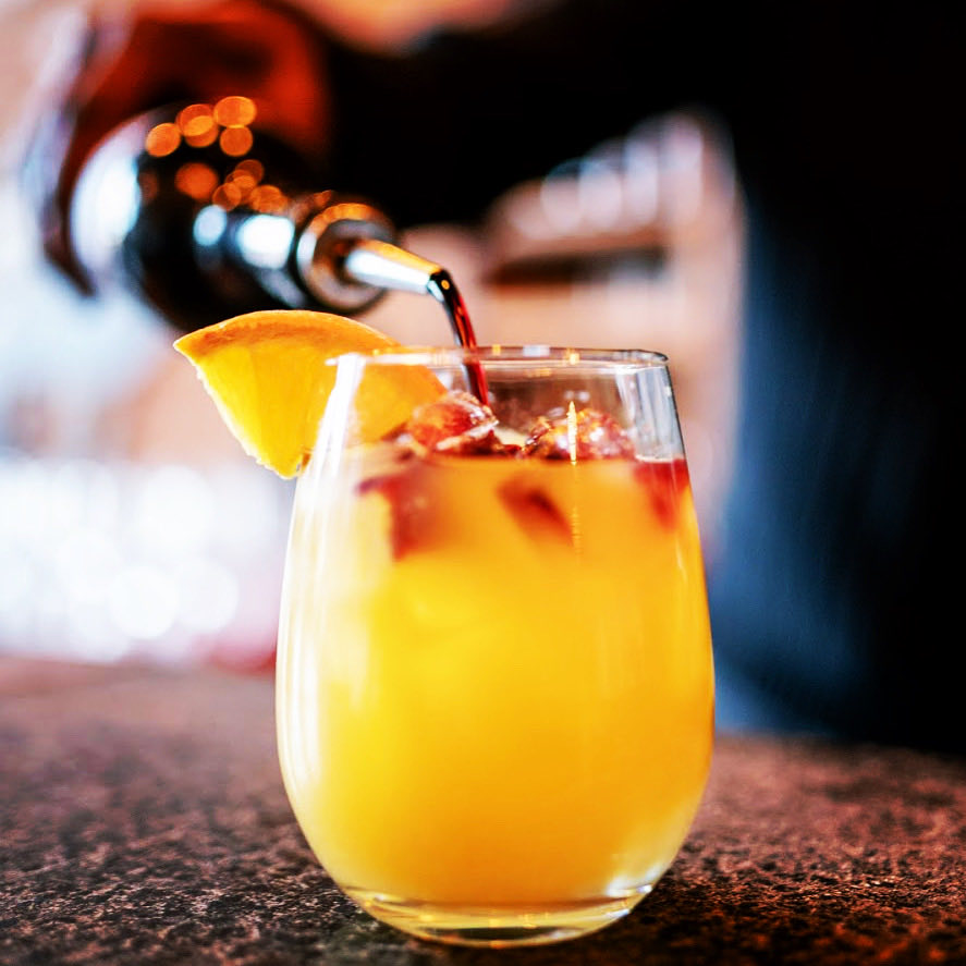 Wine slushie on tap poured over an orange slice at Revel OTR