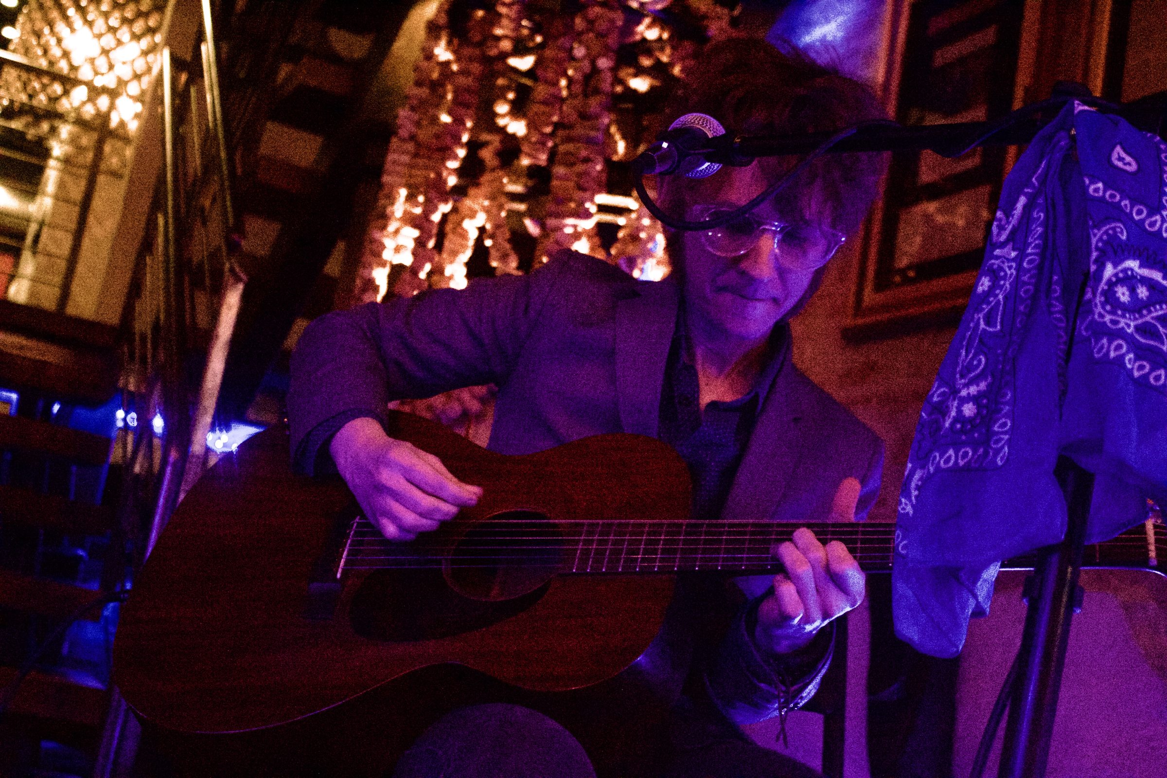 Blues guitarist performing under stage lights at Revel OTR