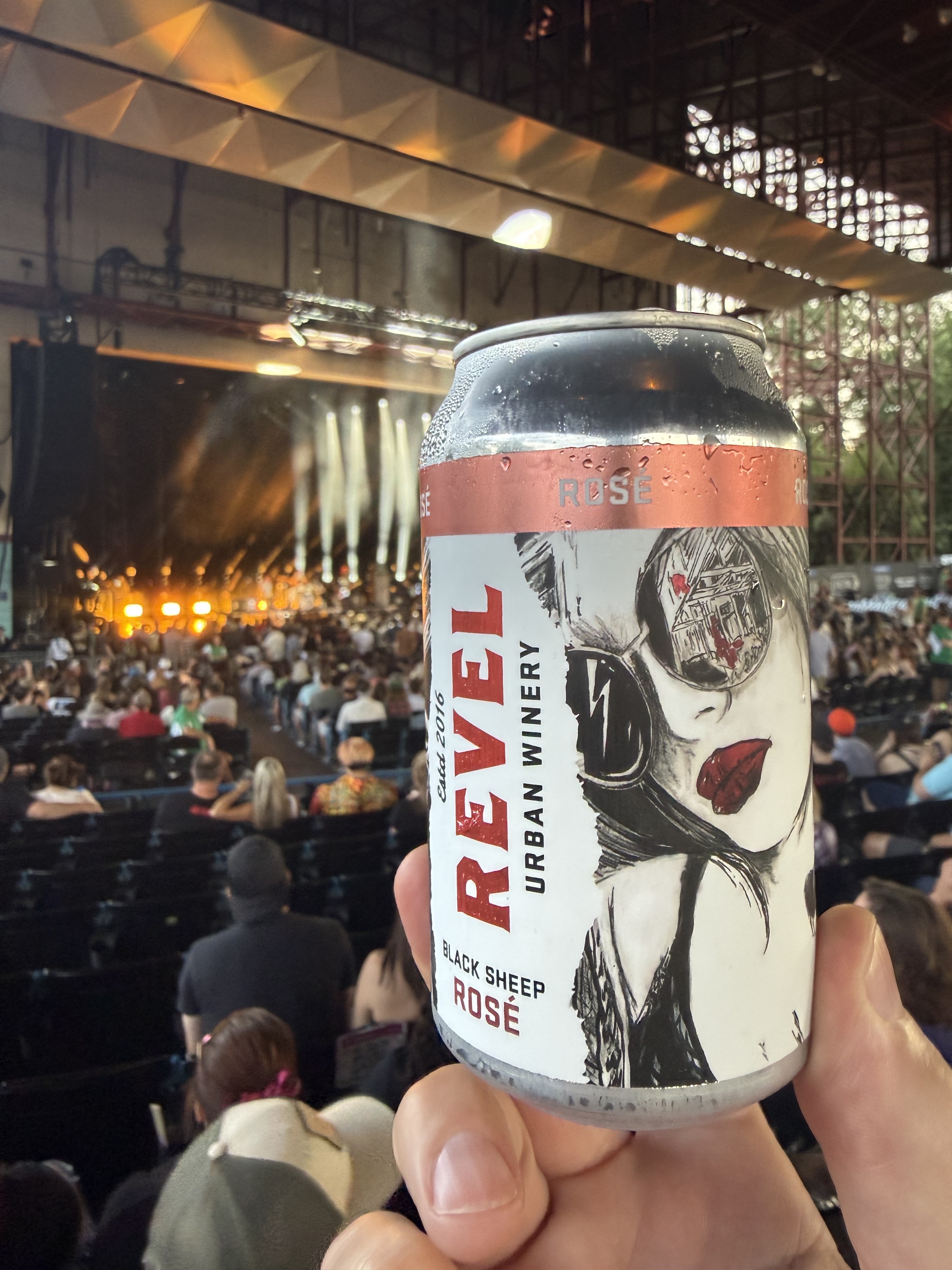 A can of Revel Black Sheep Rose held up during a concert at a Cincinnati amphitheater